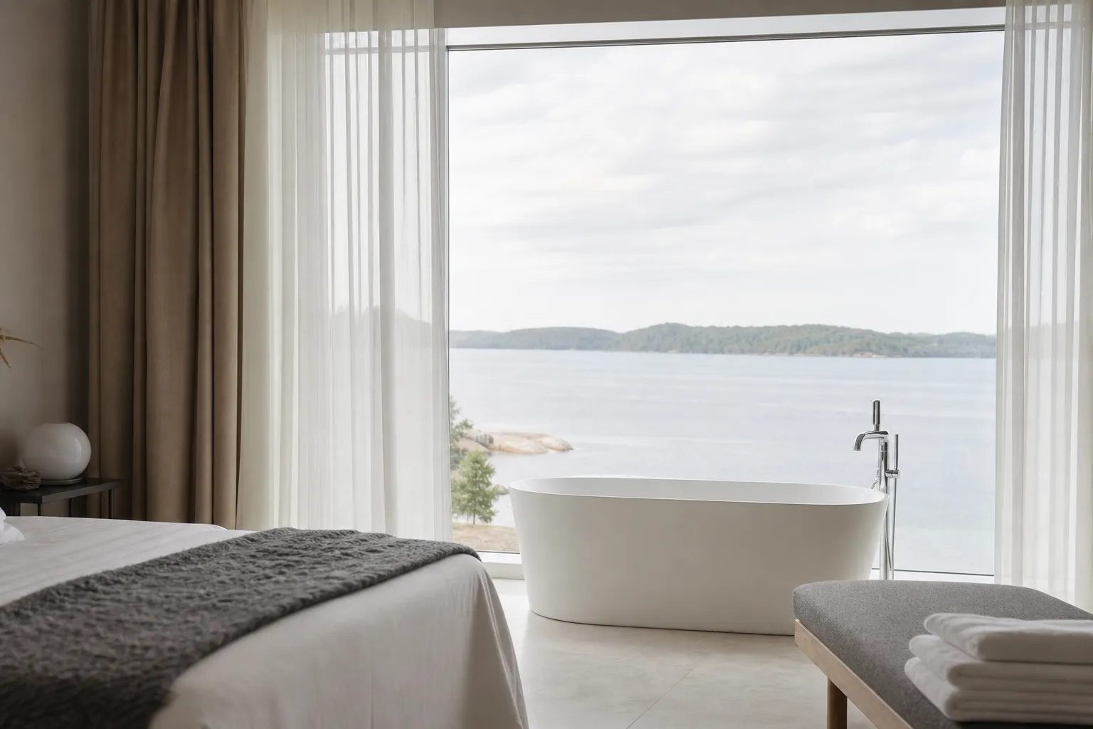 Hotellsvit med fristående badkar vid fönster och levande ljus