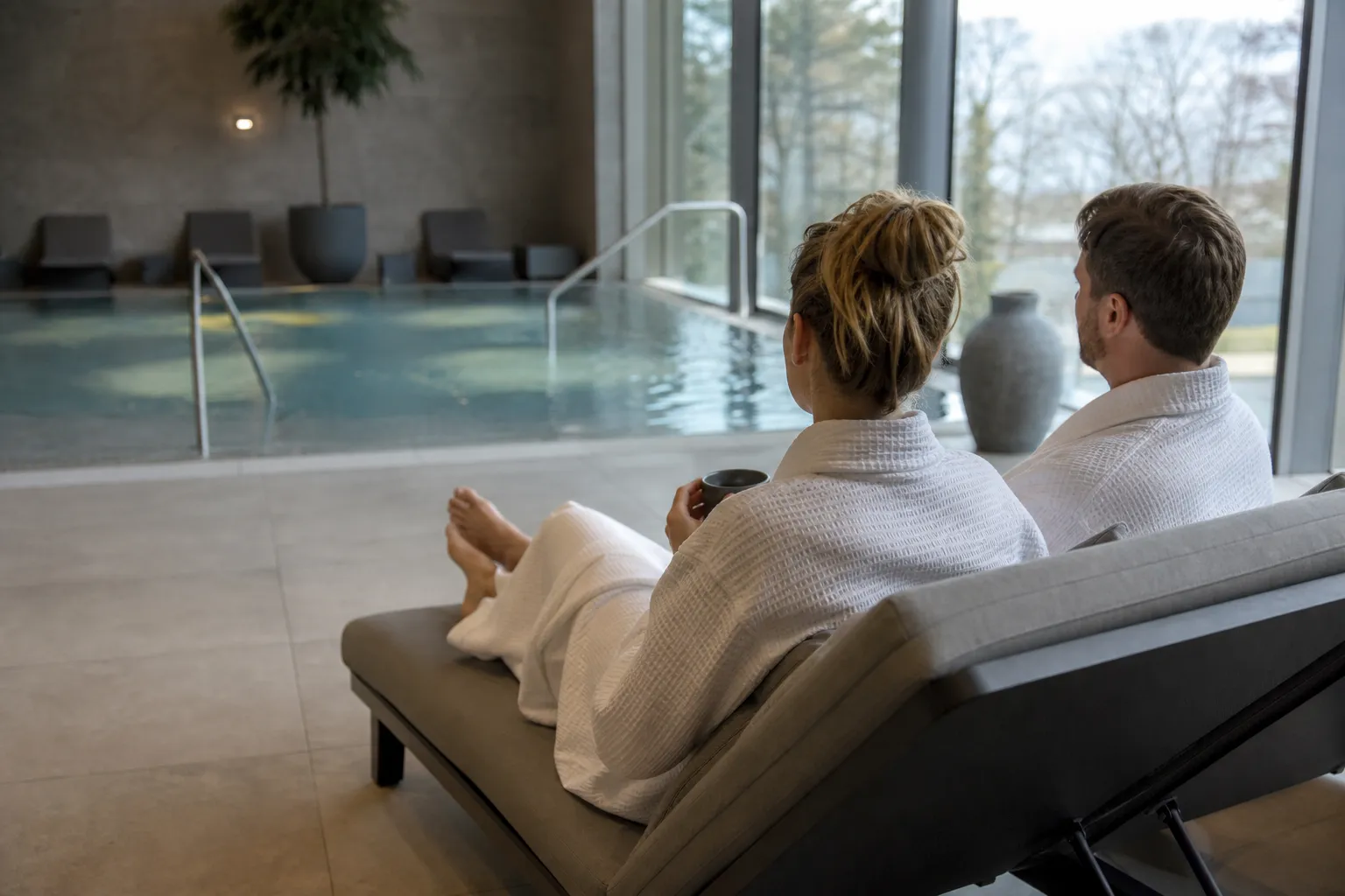 Par som kopplar av tillsammans i spaavdelning med bubbelpool